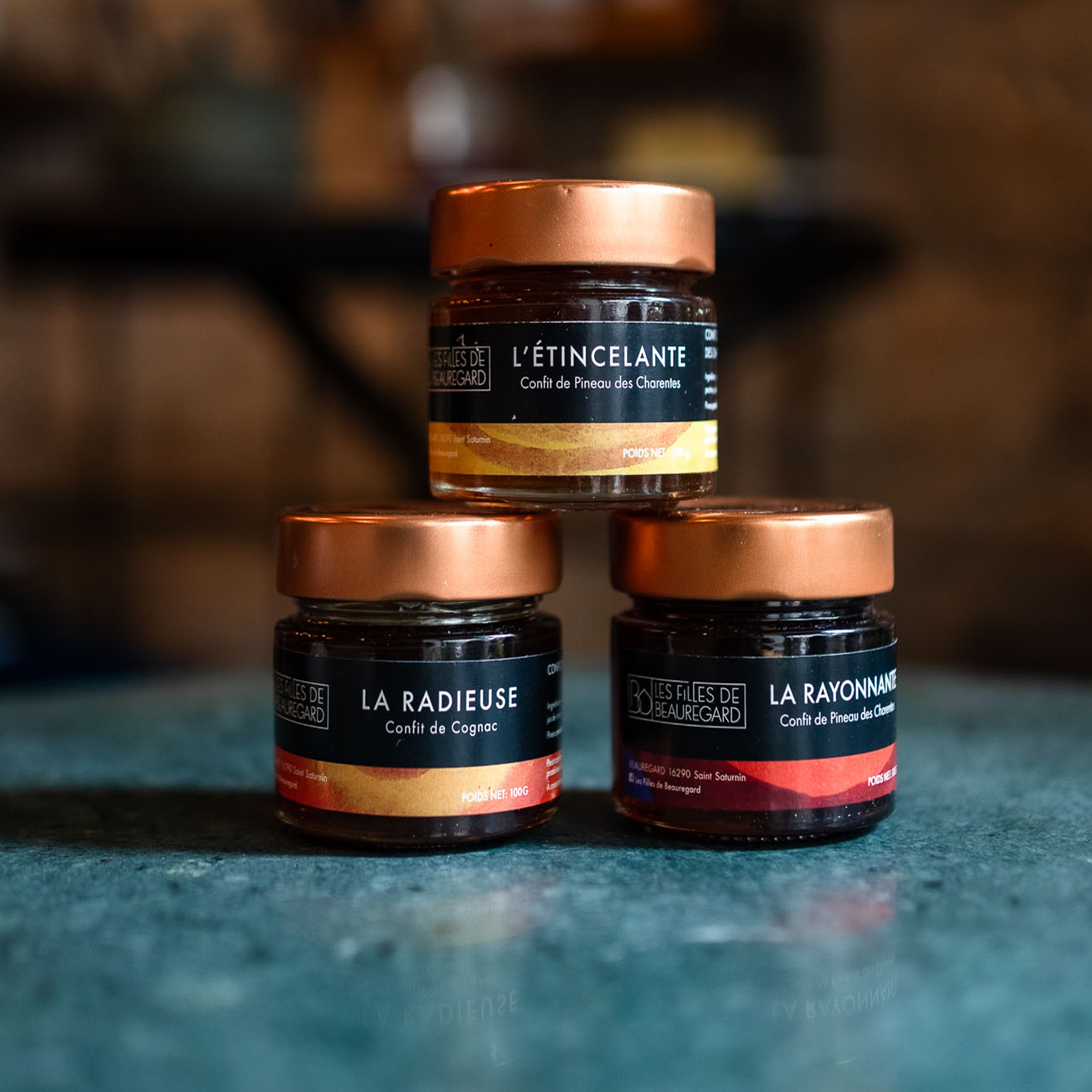 rois pots de confitures artisanales 'Les Filles de Beauregard' disposés en triangle, mettant en avant les saveurs "L'Étincelante", "La Radieuse", et "La Rayonnante"